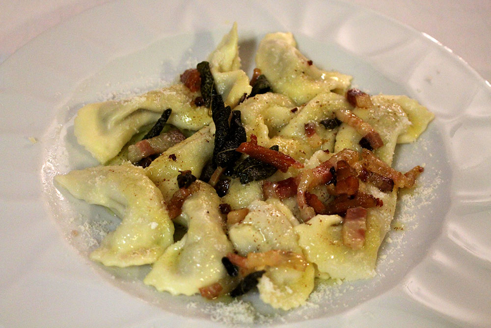 Home-made Casoncelli (ravioli) Bergamo style (dressed with Grana Padano cheese, sage, bacon and butter)